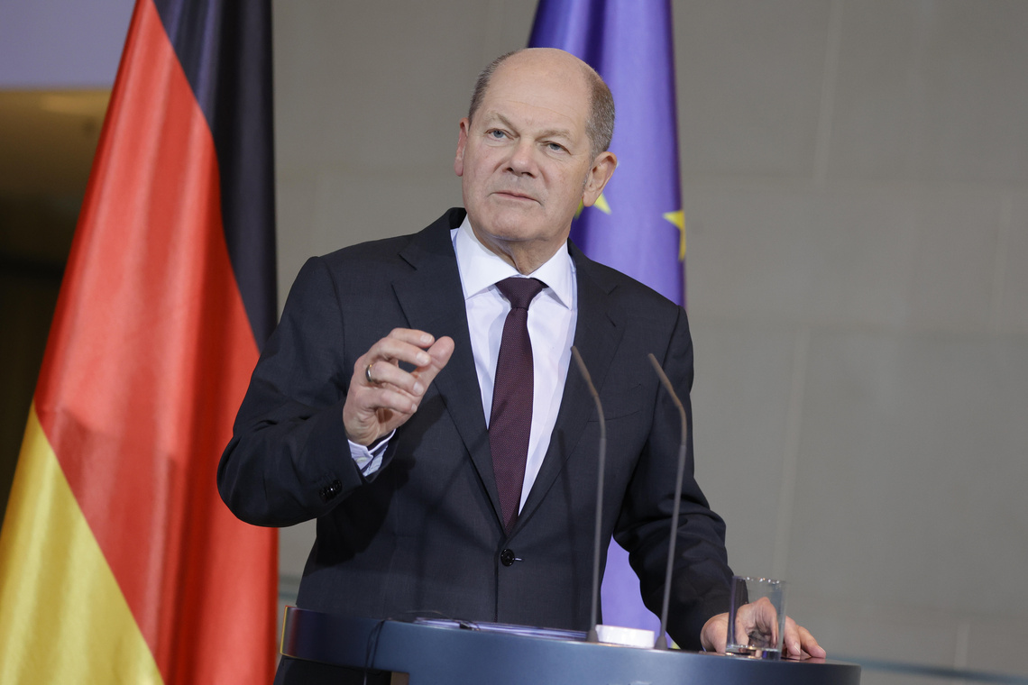 Bundeskanzler Olaf Scholz spricht an einem Rednerpult.