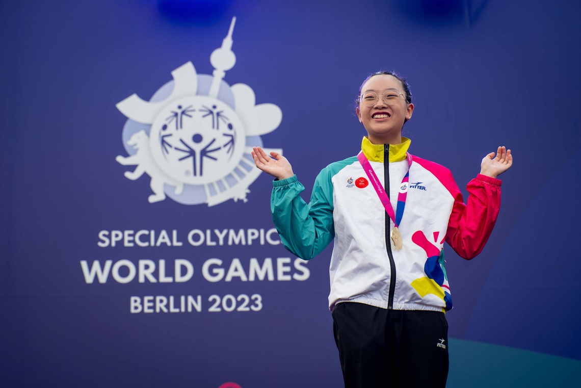 Wai aus Hong Kong freut sich über ihre erste Goldmedaille mit einem Lachen auf dem Gesicht. 