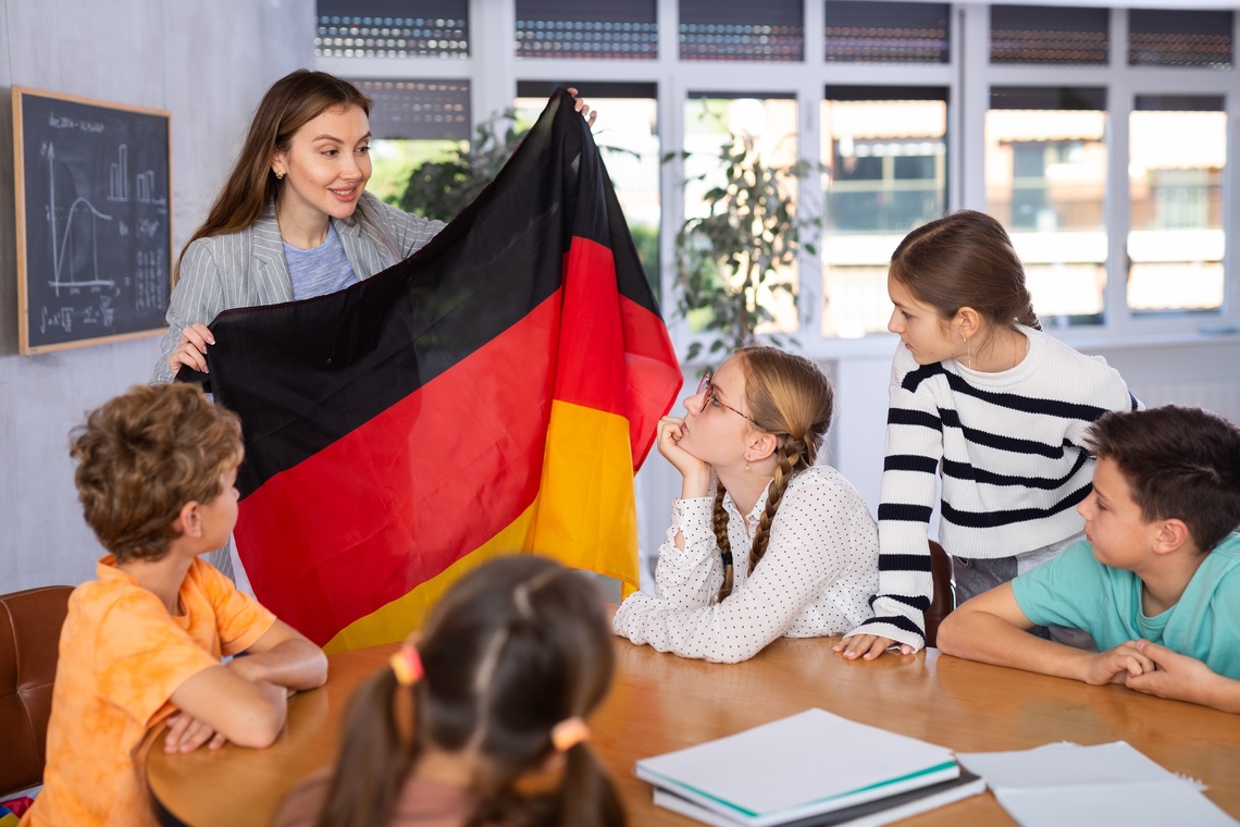 Lehrerin zeigt ihren Schülern eine Deutschland-Fahne
