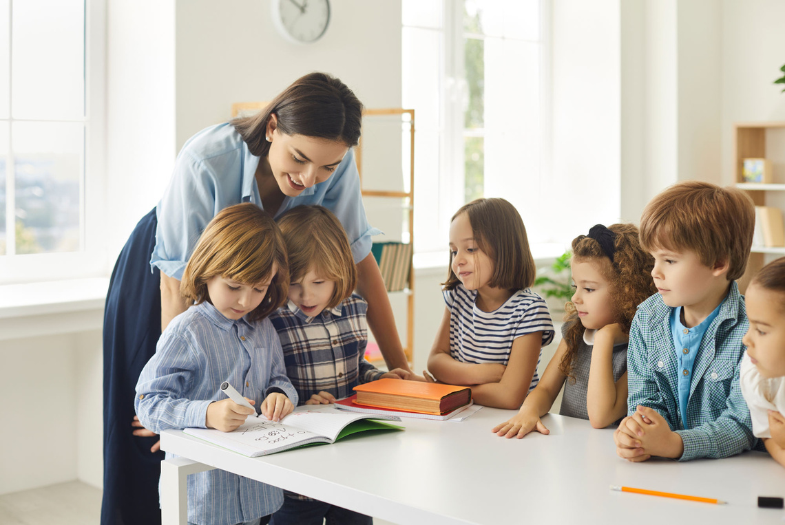 Lehrerin mit Kindern im Klassenzimmer.